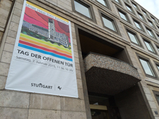 Großes Banner am Rathaus Stuttgart kündigt den "Tag der offenen Tür" am 2. Februar an; modernes Gebäude mit vielen Fenstern und bunter Illustration, barrierefreier Zugang für Besucher, Veranstaltungshinweis sichtbar.